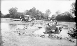 Cars stuck in river, possibly 1930? 