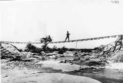 Railway line washed away by flash floods. Trolley and man standing on railway tracks, hanging in the air 