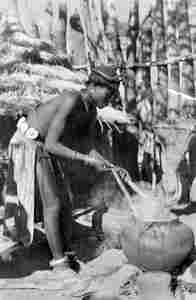 Woman handling pot on fire